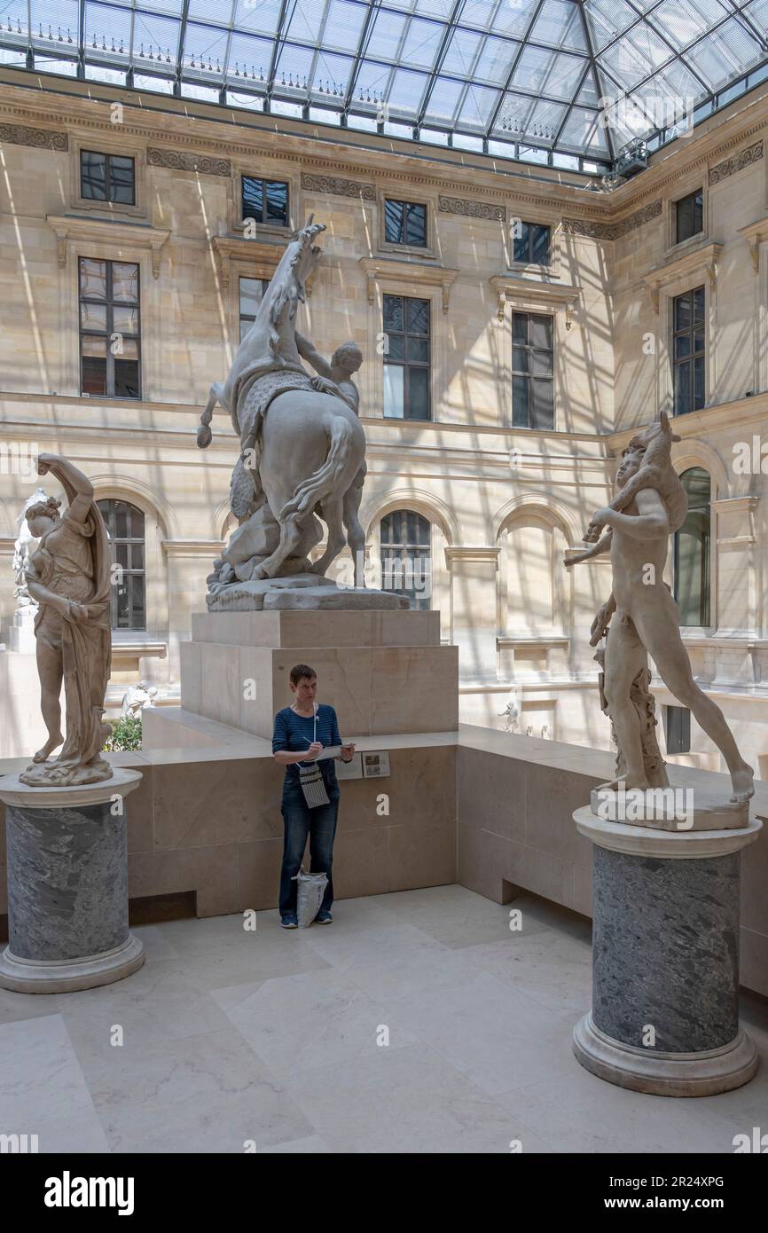 Paris, France - 05 13 2023 : Musée du Louvre. Une femme dessine la Sculpture dans la Cour Marly Banque D'Images