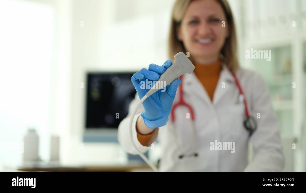 Femme souriante échologiste médecin tenant la sonde en clinique de près Banque D'Images