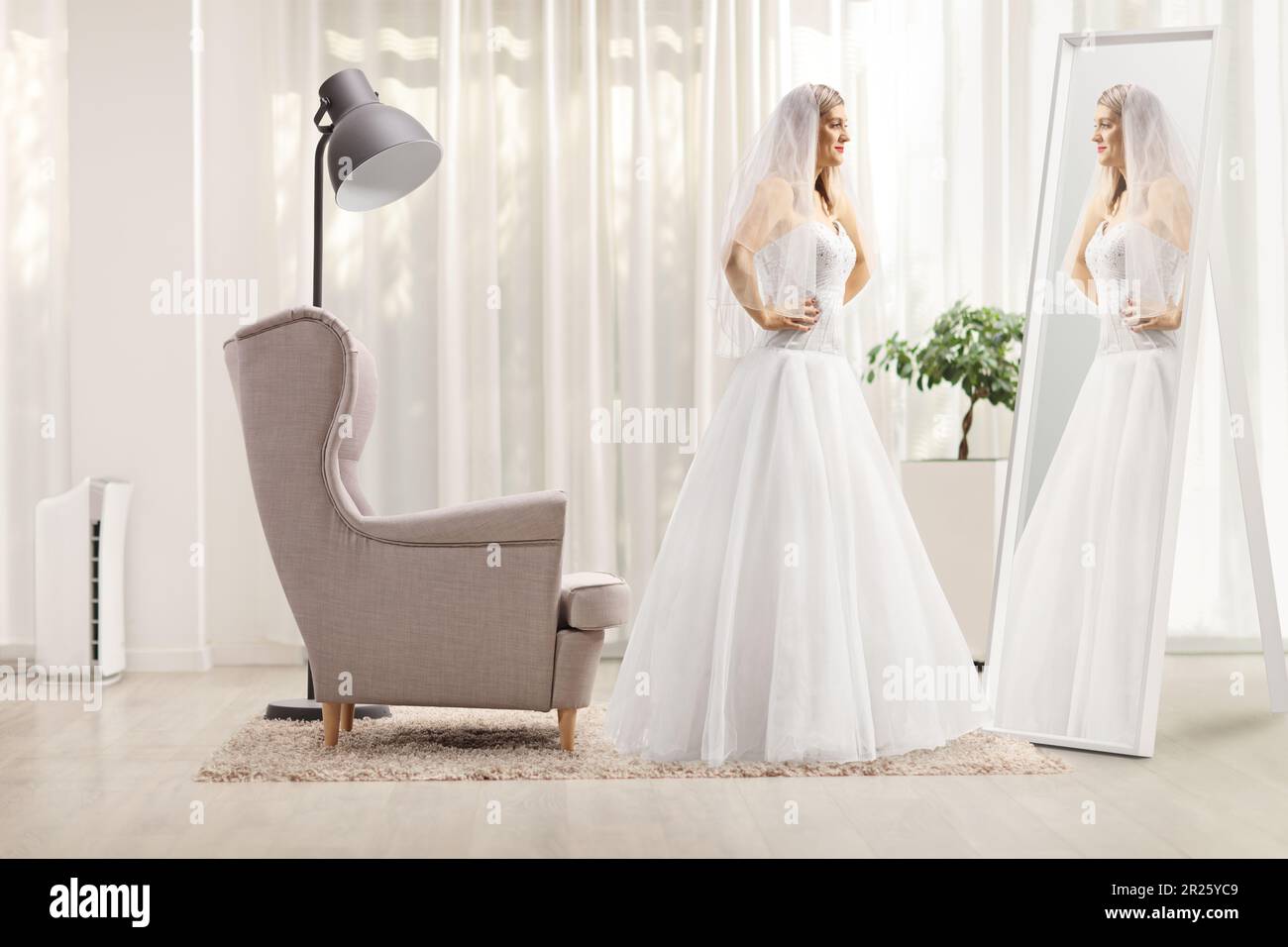 Photo de profil pleine longueur d'une mariée debout devant un miroir à la maison Banque D'Images