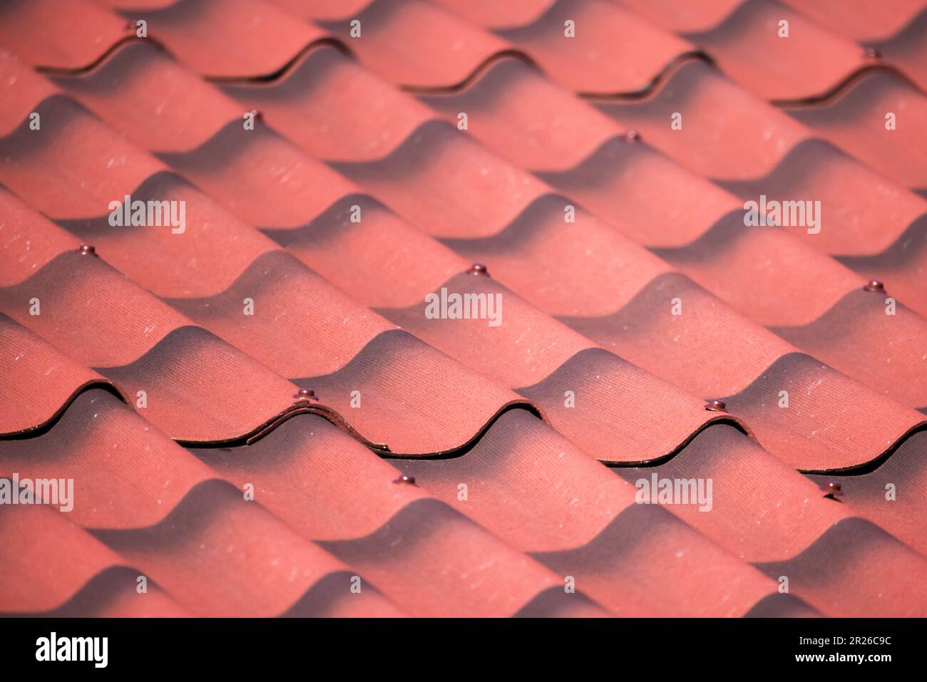 Imitation de carrelage de toit rouge de feuilles ondulées d'ardoise, gros plan photo de fond de la maison de campagne moderne toit Banque D'Images