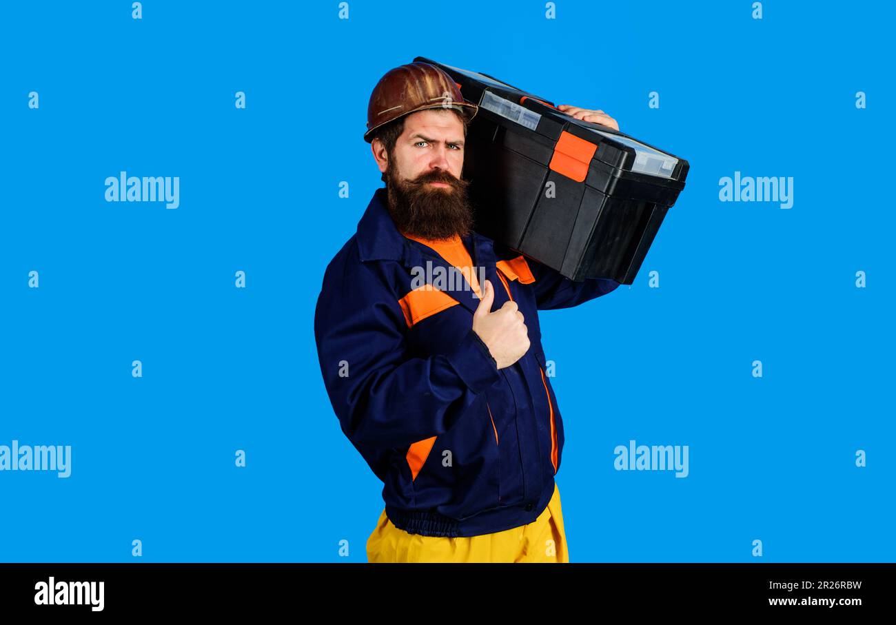 Réparer la maison. Réparateur dans un casque de sécurité avec boîte à outils montrant le pouce vers le haut. Homme de main, artisan avec kit de réparation. Construction sérieuse en uniforme avec boîte à outils Banque D'Images