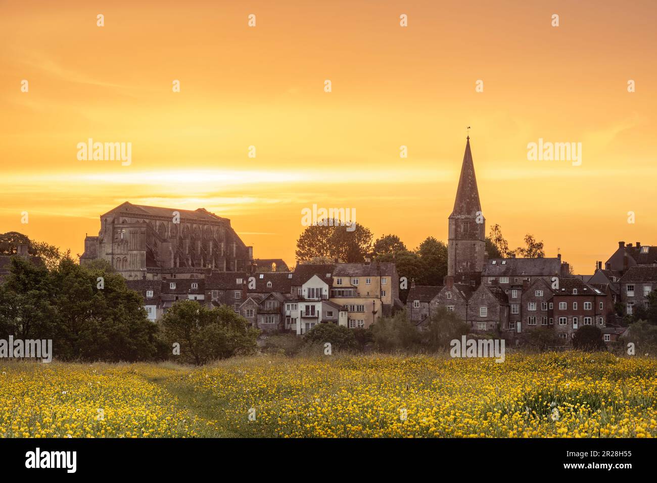 Jeudi 18th mai 2023. Malmesbury, Wiltshire, Angleterre - alors que le soleil se lève derrière l'abbaye historique, le ciel devient jaune pour correspondre à la prairie de buttercups à la ville de Malmesbury, à flanc de colline, dans le Wiltshire. Crédit : Terry Mathews/Alay Live News Banque D'Images