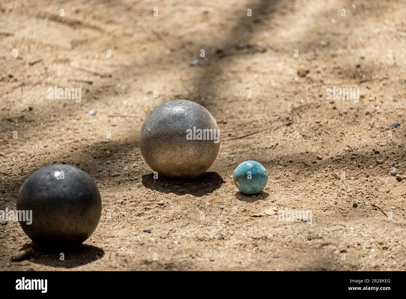 Deux boules de métal du jeu de pétanque approchant le bowling sur un  terrain sablonneux d'un terrain de pétanque par une journée ensoleillée avec  les ombres du tr Photo Stock - Alamy