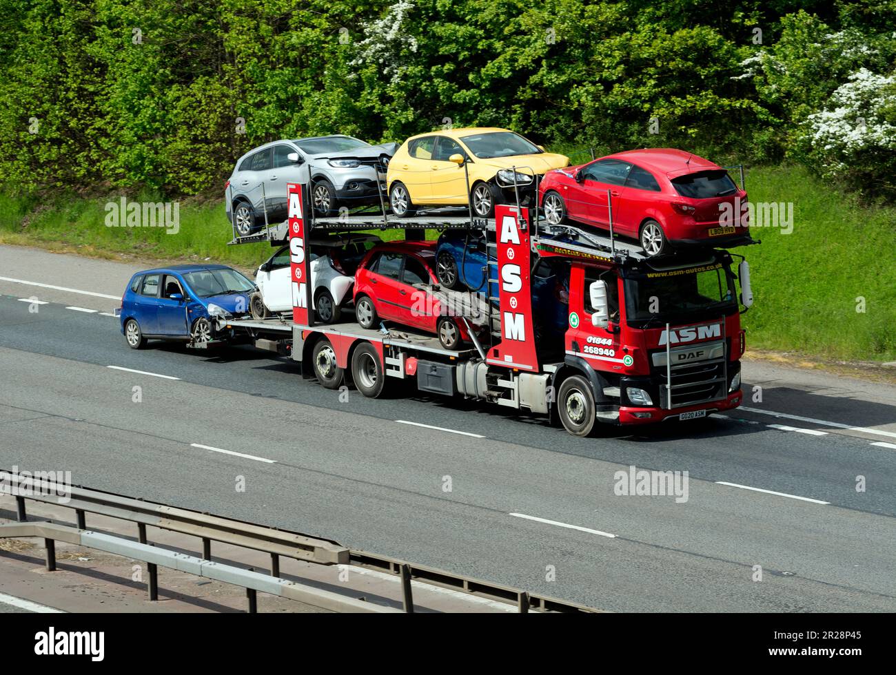 Camion ASM transportant des voitures endommagées par accident sur l'autoroute M40, Warwickshire, Royaume-Uni Banque D'Images