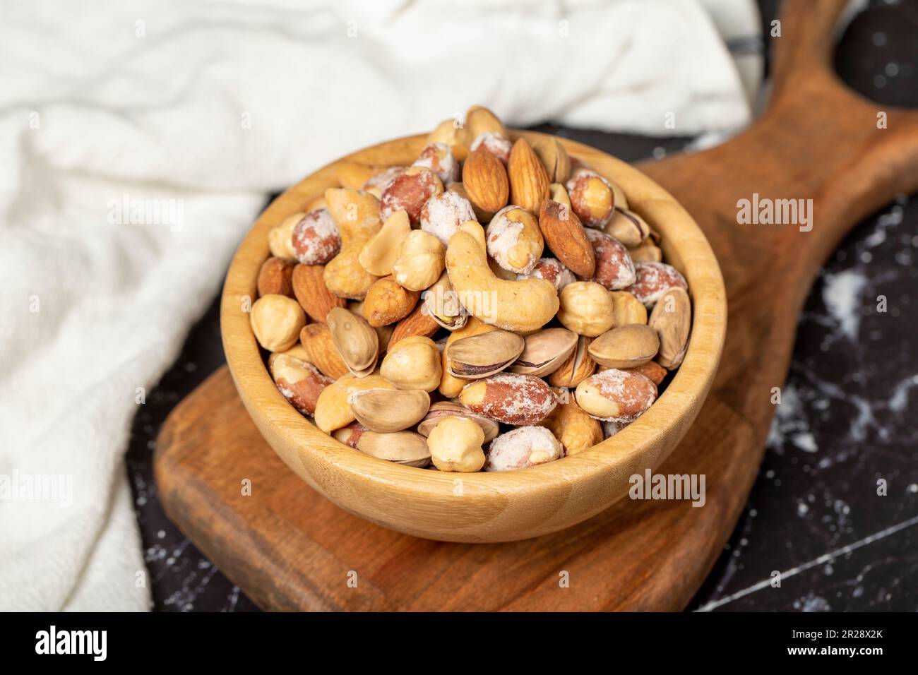 Noix mélangées. Noix spéciales mélangées dans un bol en bois. Noix, pistaches, arachides, noix de cajou, amandes. Superfood concept de la nourriture végétarienne. des collations saines. Fermer Banque D'Images