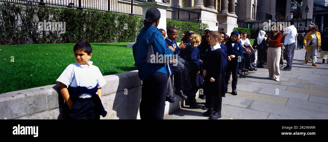 Enfants et enseignants en voyage scolaire à Trafalgar Square, Londres, Angleterre Banque D'Images