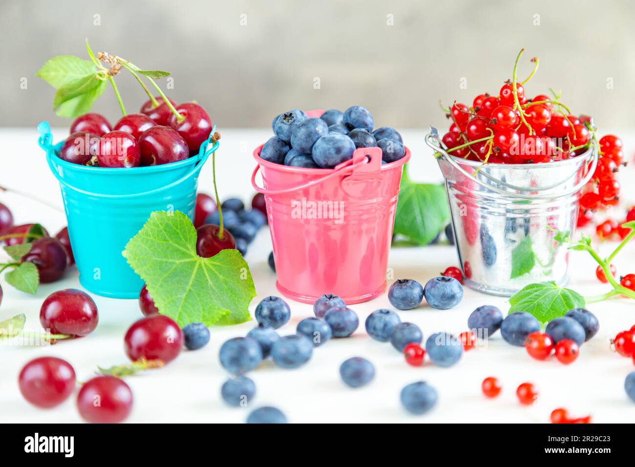Mélanger les baies fraîches dans de petits seaux. Papier peint d'été juteux. Banque D'Images