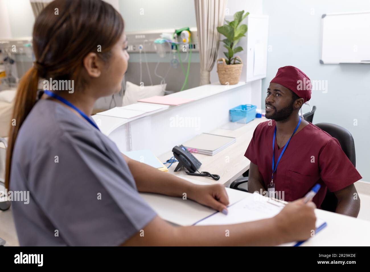 Divers médecins et infirmières de sexe masculin écrivant et parlant à l'hôpital Banque D'Images