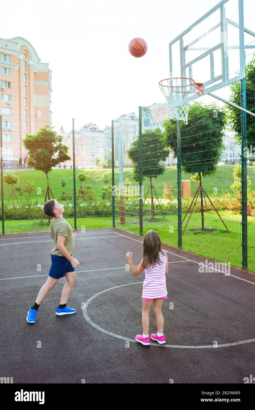 Les enfants jouent au basket-ball sur l'aire de jeux de la ville. Jeu de  basketball de streetball avec deux joueurs Photo Stock - Alamy