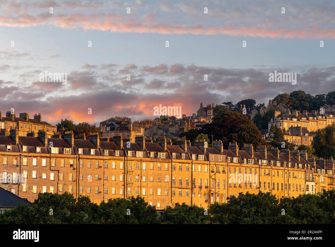 Vue à angle bas d'une longue rangée de maisons typiques avec toits et cheminées de maisons géorgiennes à Bath, Sommerset, Royaume-Uni couleur orange vif pendant Banque D'Images