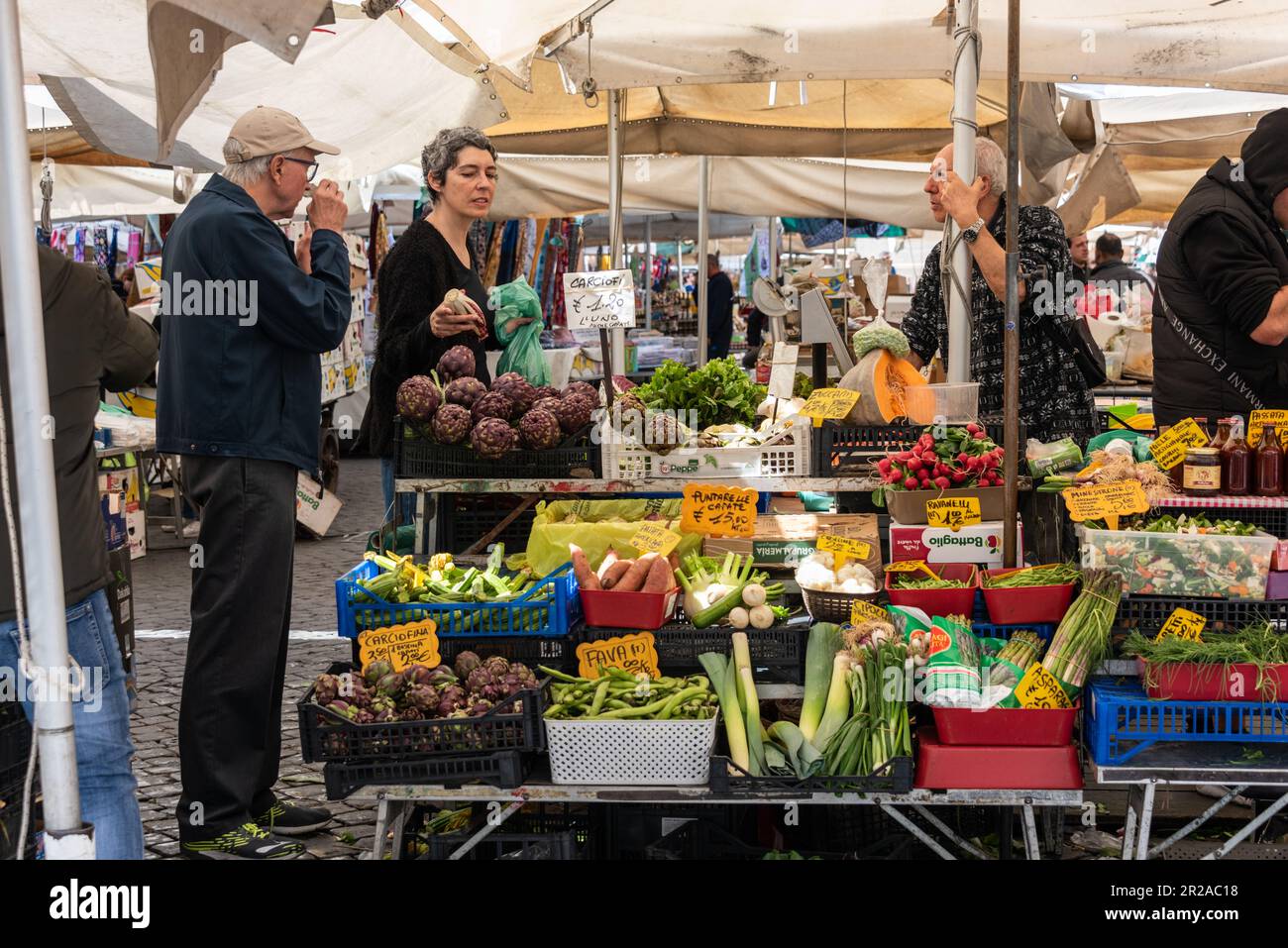 ROM, Italien, März 2023 Einkaufszene am frühen morgen auf dem Campo dei Fiori, Eine Kundin prüft das Angebot des Gemüsehändlers Banque D'Images