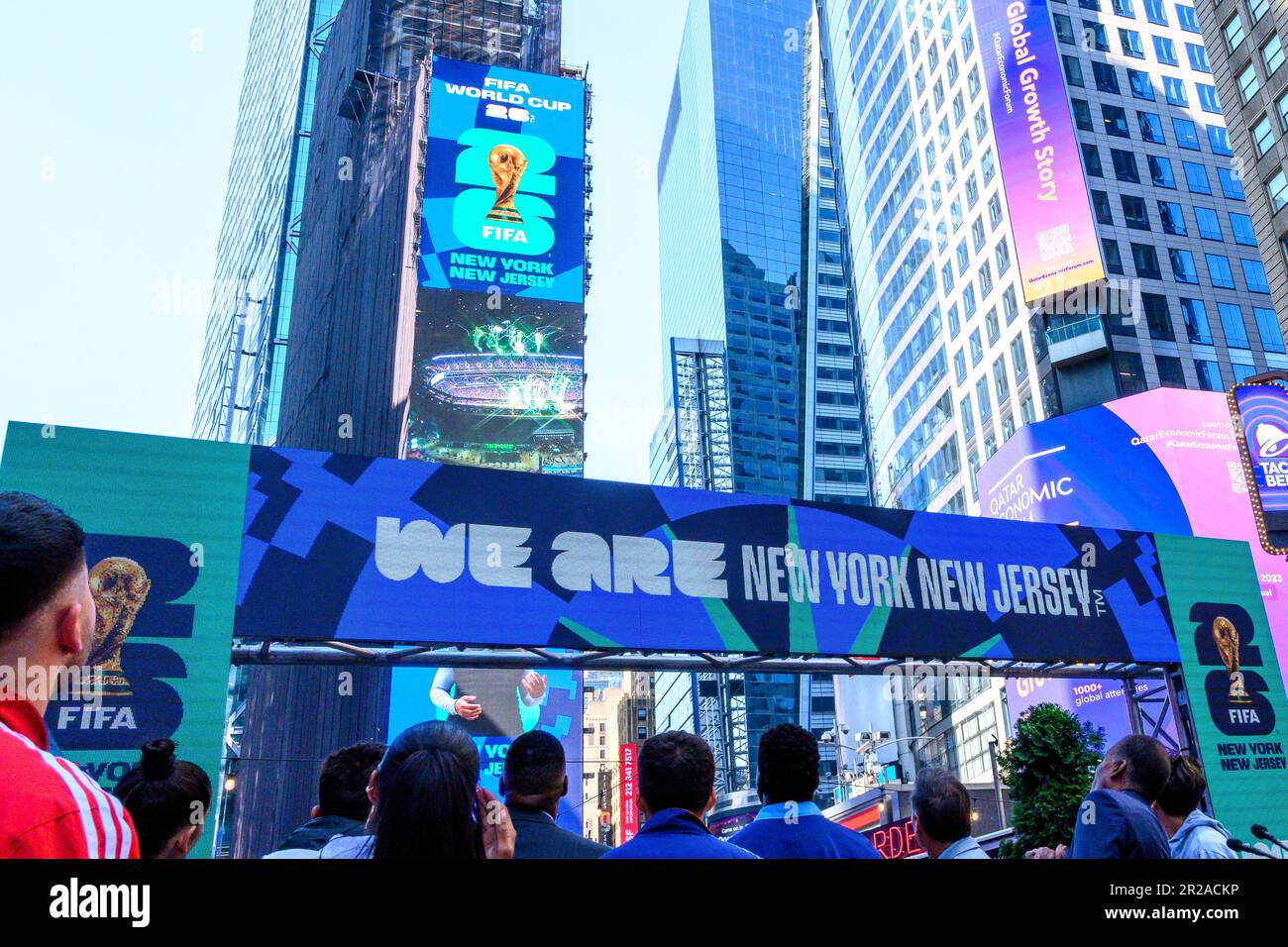 New York, États-Unis. 18th mai 2023. Les gens regardent des panneaux publicitaires affichant les logos officiels de la coupe du monde de la FIFA 2026 New York/New Jersey lors d'un événement de lancement à Times Square. L'événement a dévoilé les thèmes officiels des matchs du stade MetLife : « We are NYNJ » et « We are 26 ». La meilleure compétition de football au monde prévoit déjà d'accueillir 8 matchs dans la région de New York/New Jersey et les organisateurs locaux souhaitent également accueillir le match final ici. Credit: Enrique Shore/Alay Live News Banque D'Images