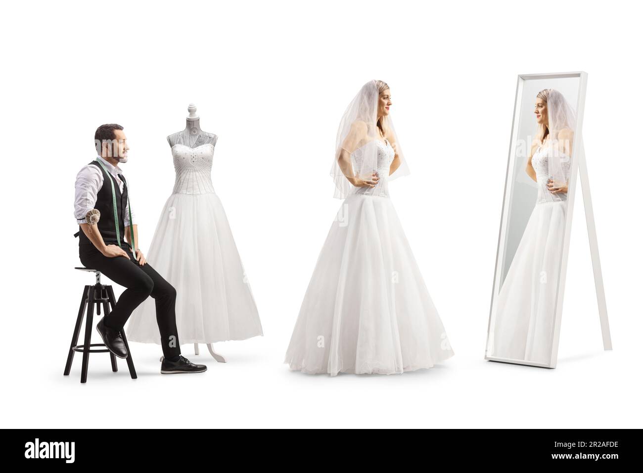 Mariée essayant une robe à l'atelier de tailleurs et regardant un miroir isolé sur fond blanc Banque D'Images