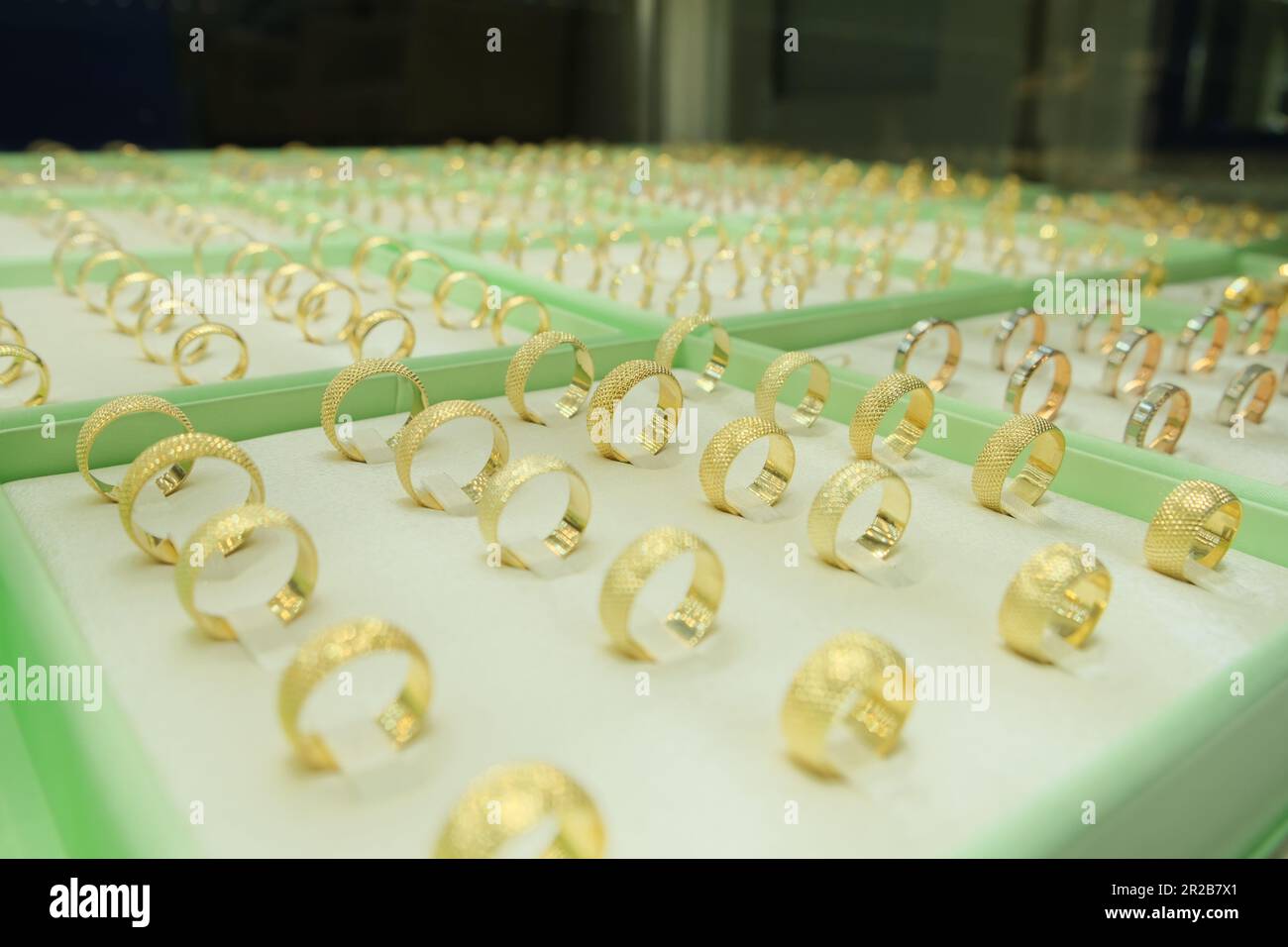 Les anneaux d'engagement de bijoux en or sont présentés dans la vitrine du magasin de détail. Idée de photo de concept de vitrine de bijoux. Banque D'Images