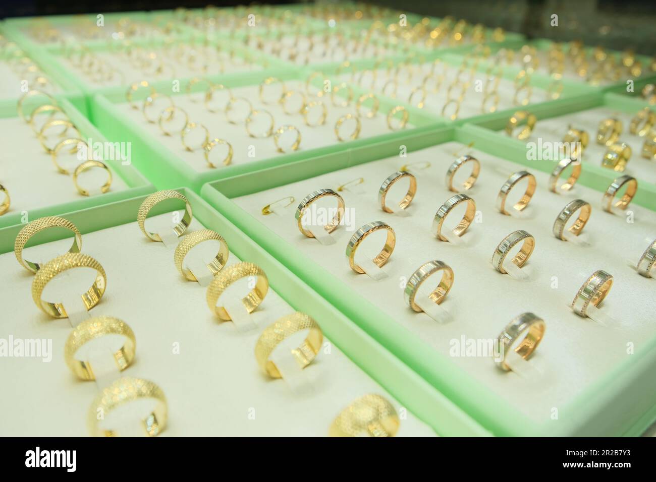 Les anneaux d'engagement de bijoux en or sont présentés dans la vitrine du magasin de détail. Idée de photo de concept de vitrine de bijoux. Banque D'Images