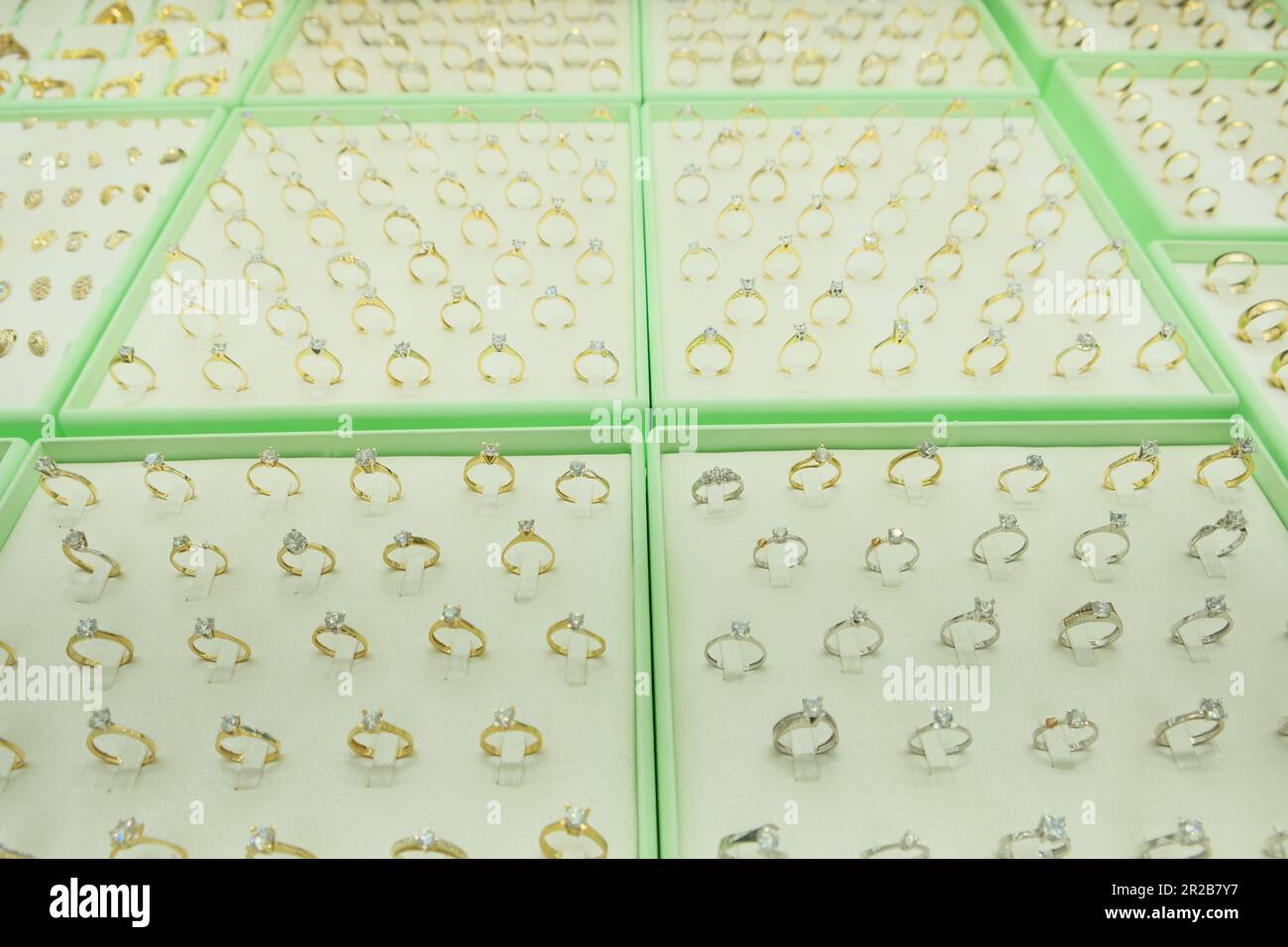 Les anneaux en diamant doré sont présentés dans la vitrine du magasin. Idée de photo de concept de vitrine de bijoux. Banque D'Images