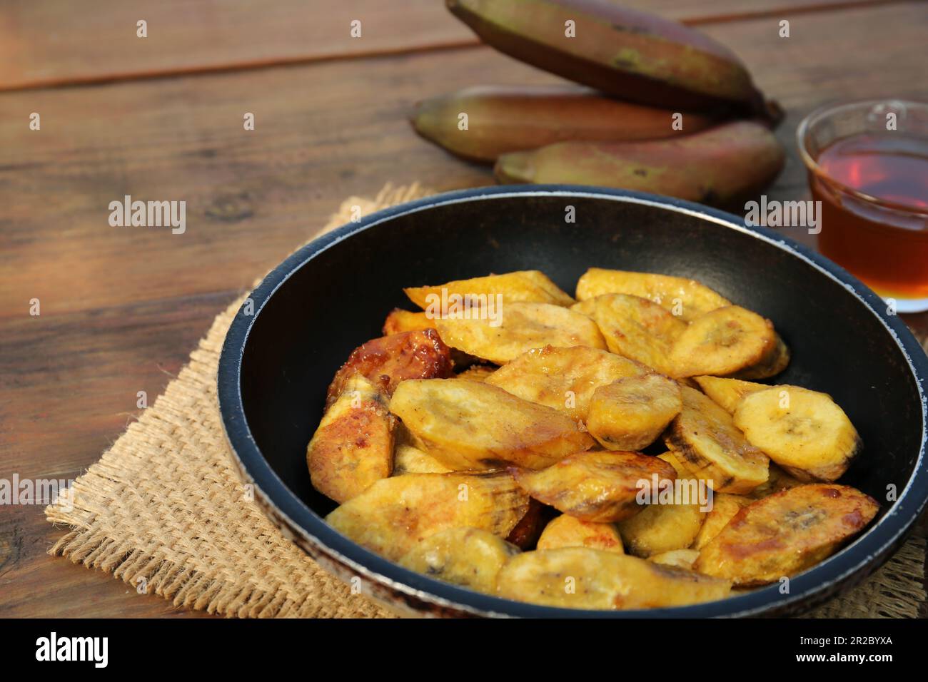 De savoureuses tranches de banane frite sur une table en bois Banque D'Images