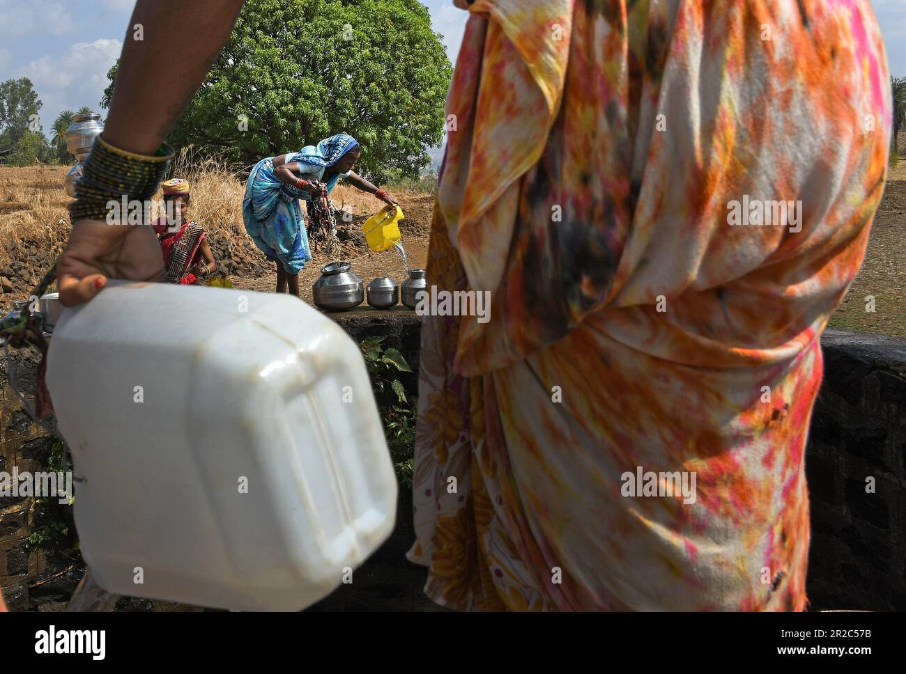 Mumbai, Inde. 16th mai 2023. Une femme est vue verser de l'eau dans le bateau après l'avoir tiré du puits dans le village de Telamwadi près de Vihigaon, Shahapur taluka du district de Thane près de Mumbai. Les villageois sont confrontés à une pénurie aiguë d'eau pendant les mois d'été, car ils reçoivent l'eau par camion transportant de l'eau qui ne vide l'eau dans le puits qu'une fois par jour, ce qui est insuffisant pour eux et leur bétail pour une utilisation quotidienne. Crédit : SOPA Images Limited/Alamy Live News Banque D'Images