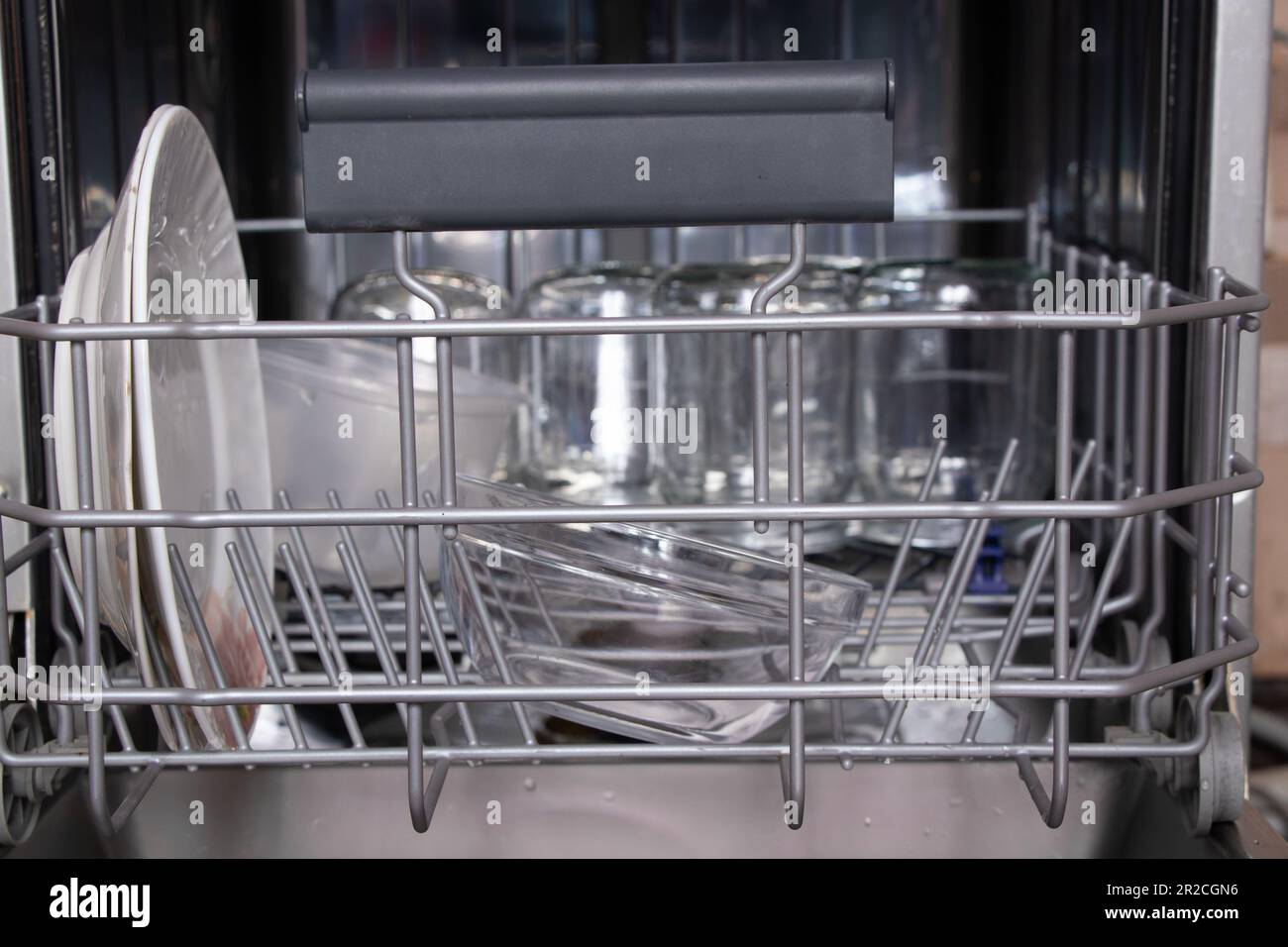 panier avec vaisselle propre dans le lave-vaisselle dans la cuisine, lave-vaisselle avec une plaque Banque D'Images