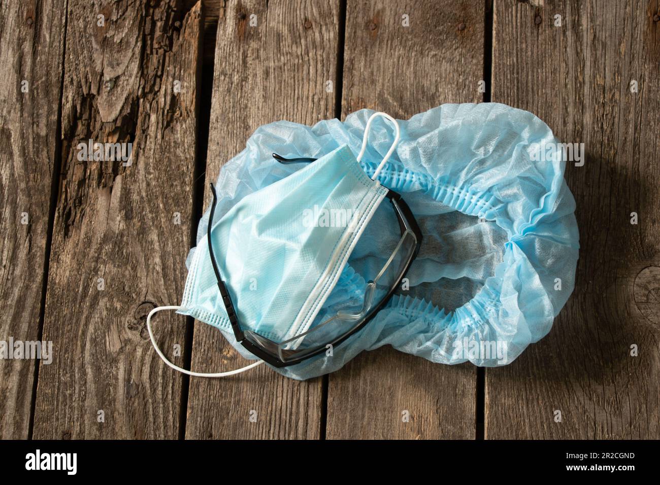 masque médical de lunettes de chapeau se trouvent sur une table en bois, l'uniforme du médecin Banque D'Images