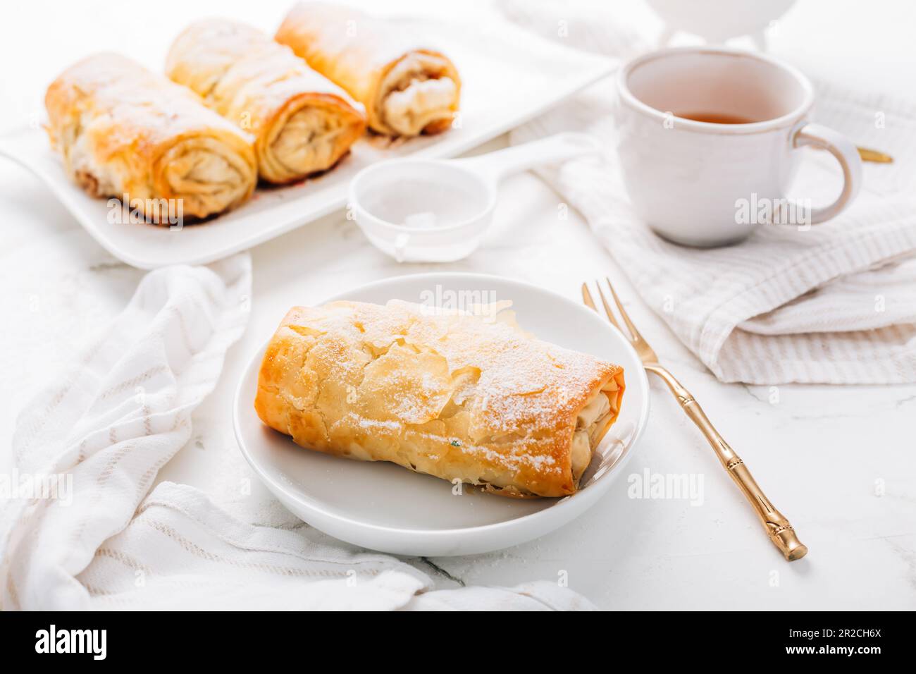 Strudel aux pommes maison à la cannelle, tarte aux pommes avec une tasse de thé aux fruits Banque D'Images