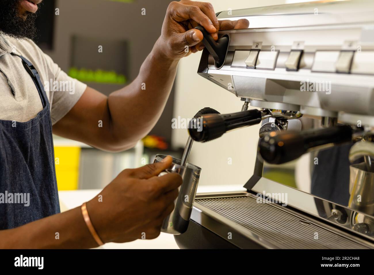 Milieu de section de barista afro-américain qui prépare un café avec une cafetière au café-restaurant Banque D'Images