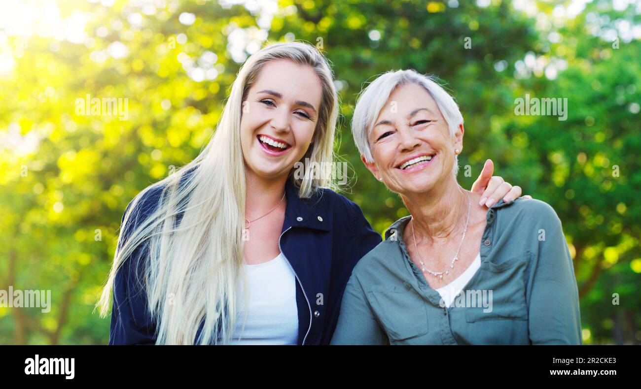 Portrait, femme âgée et fille adulte dans le parc, heureux à l'extérieur avec le hug, rire et passer du temps de qualité ensemble. Amour, confiance et relation Banque D'Images