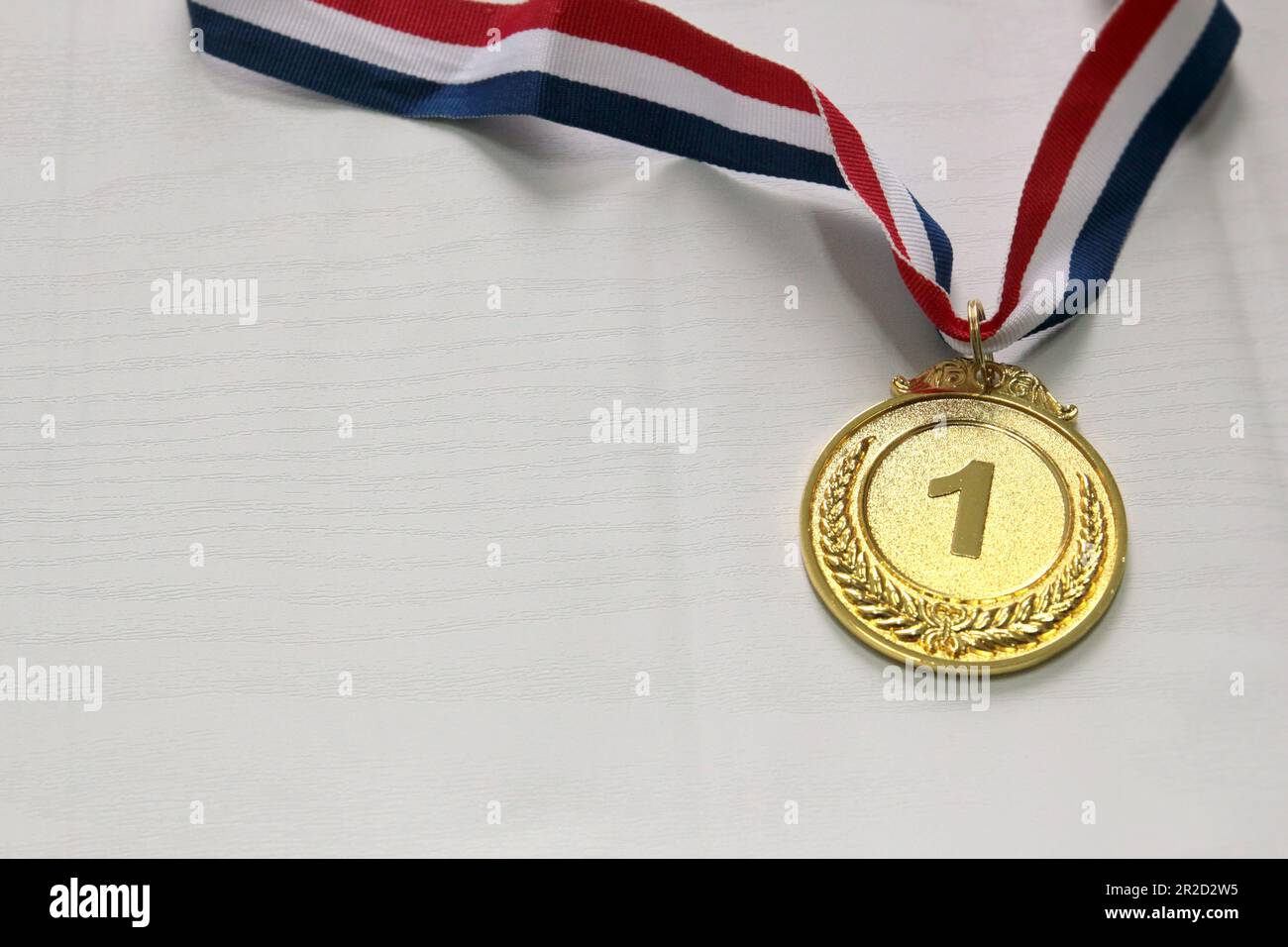 Médaille d'or au premier plan sur ruban blanc rouge bleu Banque D'Images