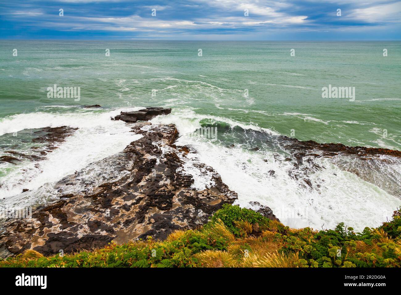 Des vagues se sont plantées sur la pointe rocheuse entre Porpoise Bay et Curio Bay dans le district de Southland, dans l'île du Sud, en Nouvelle-Zélande Banque D'Images
