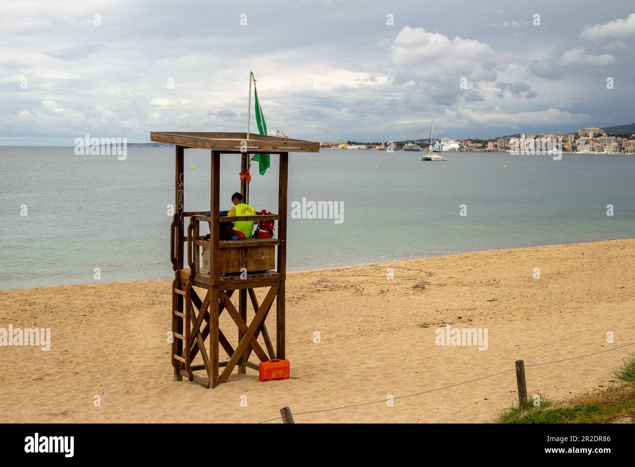 Palma de Majorque, Espagne - 13 mai 2023 : sauveteur dans une tour en bois sur la plage avec la marina de Palma en arrière-plan Banque D'Images