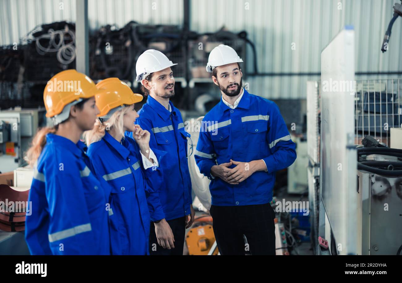 Un groupe d'ingénieurs robotisés, travaillant en collaboration, remue-méninges et discute d'idées avec des équipes interfonctionnelles sur un tableau blanc pour créer des stratégies et des solu Banque D'Images