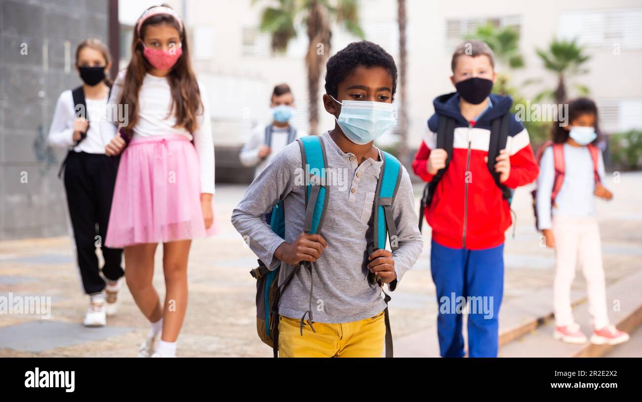 Afro-américain, entre élèves dans un masque de protection allant à l'école Banque D'Images