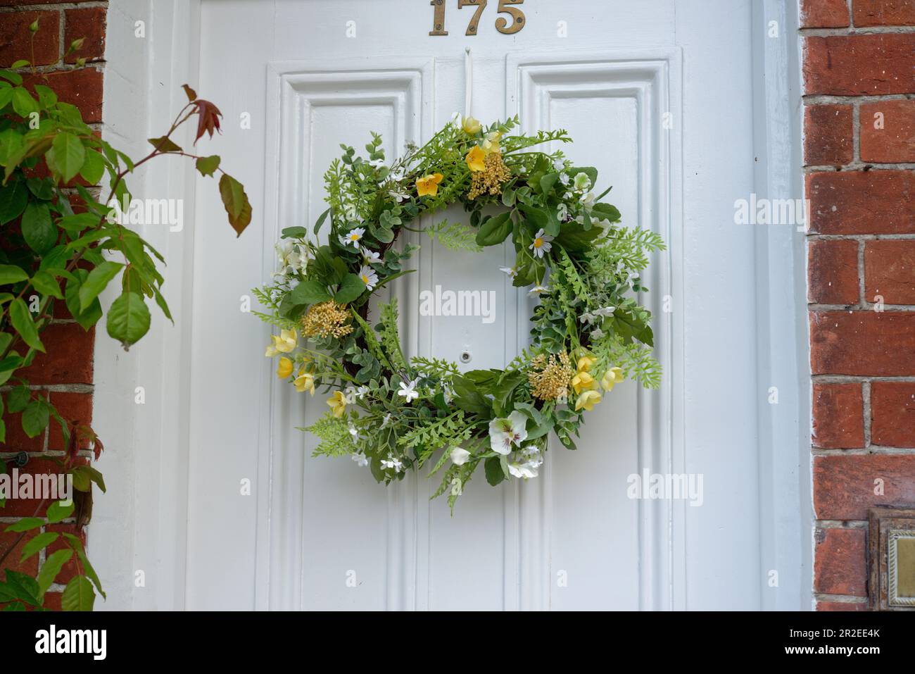L'Angleterre au printemps. Une couronne de printemps sur une porte peinte en blanc au Royaume-Uni. Banque D'Images
