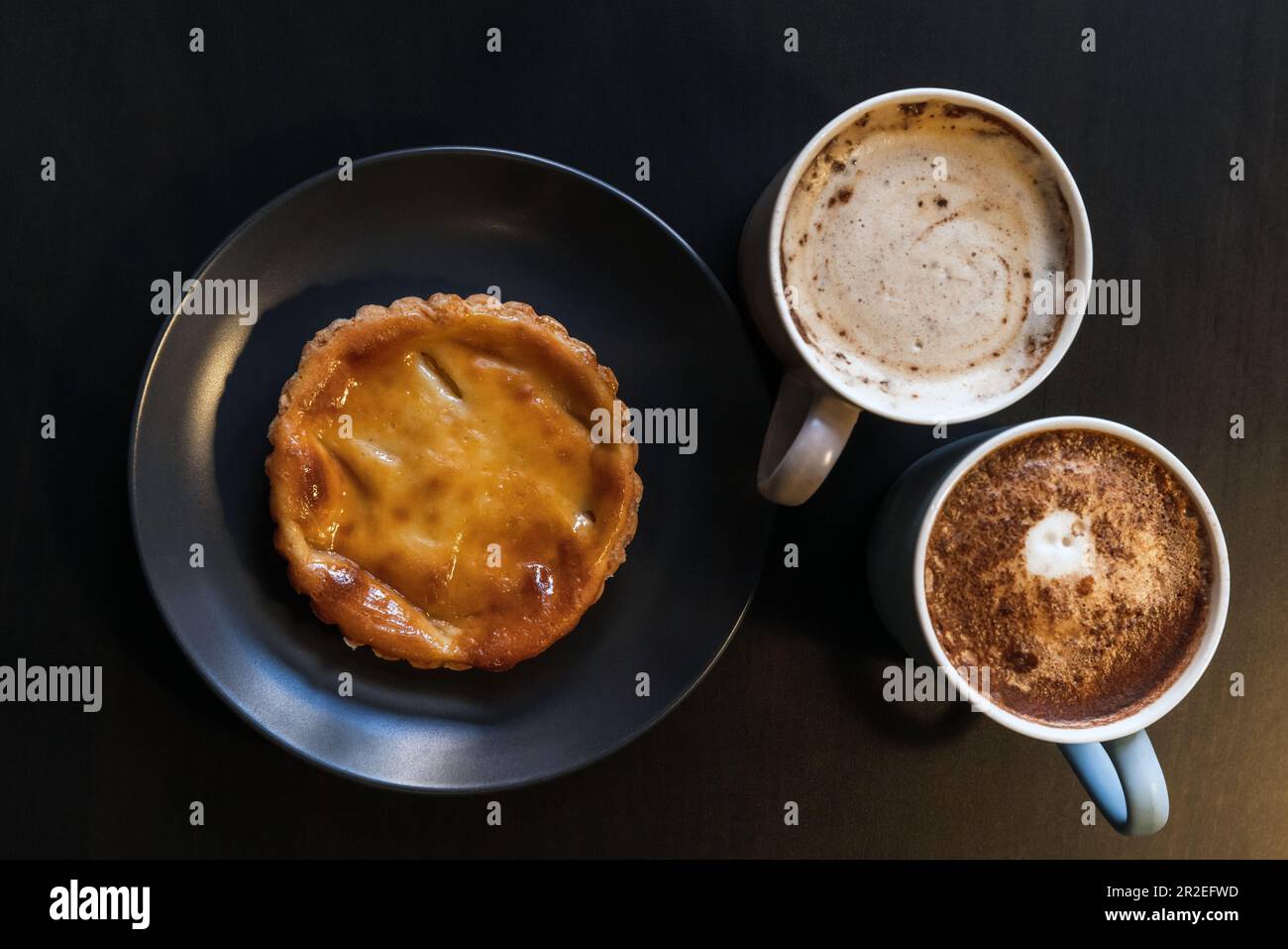 Pastel de nata et deux tasses de cappuccino, vue de dessus Banque D'Images