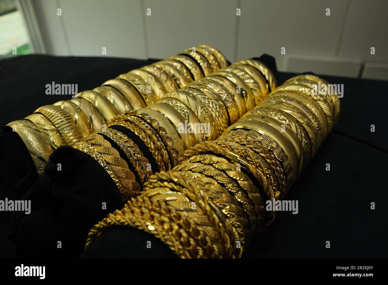 Bracelets dorés en trois groupes sur fond noir. Banque D'Images