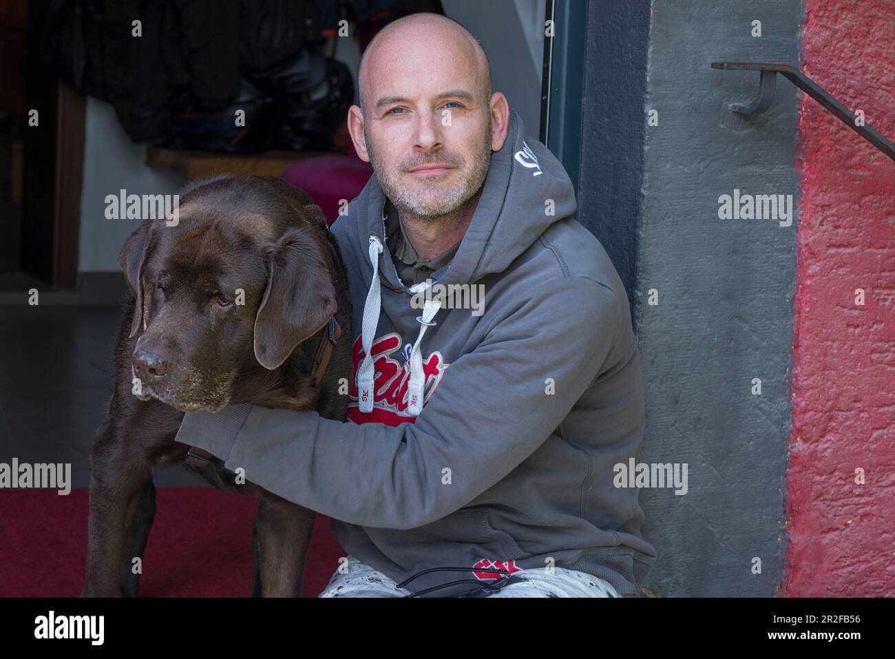 Jeune homme avec son Labrador à la porte d'entrée, Bade-Wurtemberg, Allemagne Banque D'Images