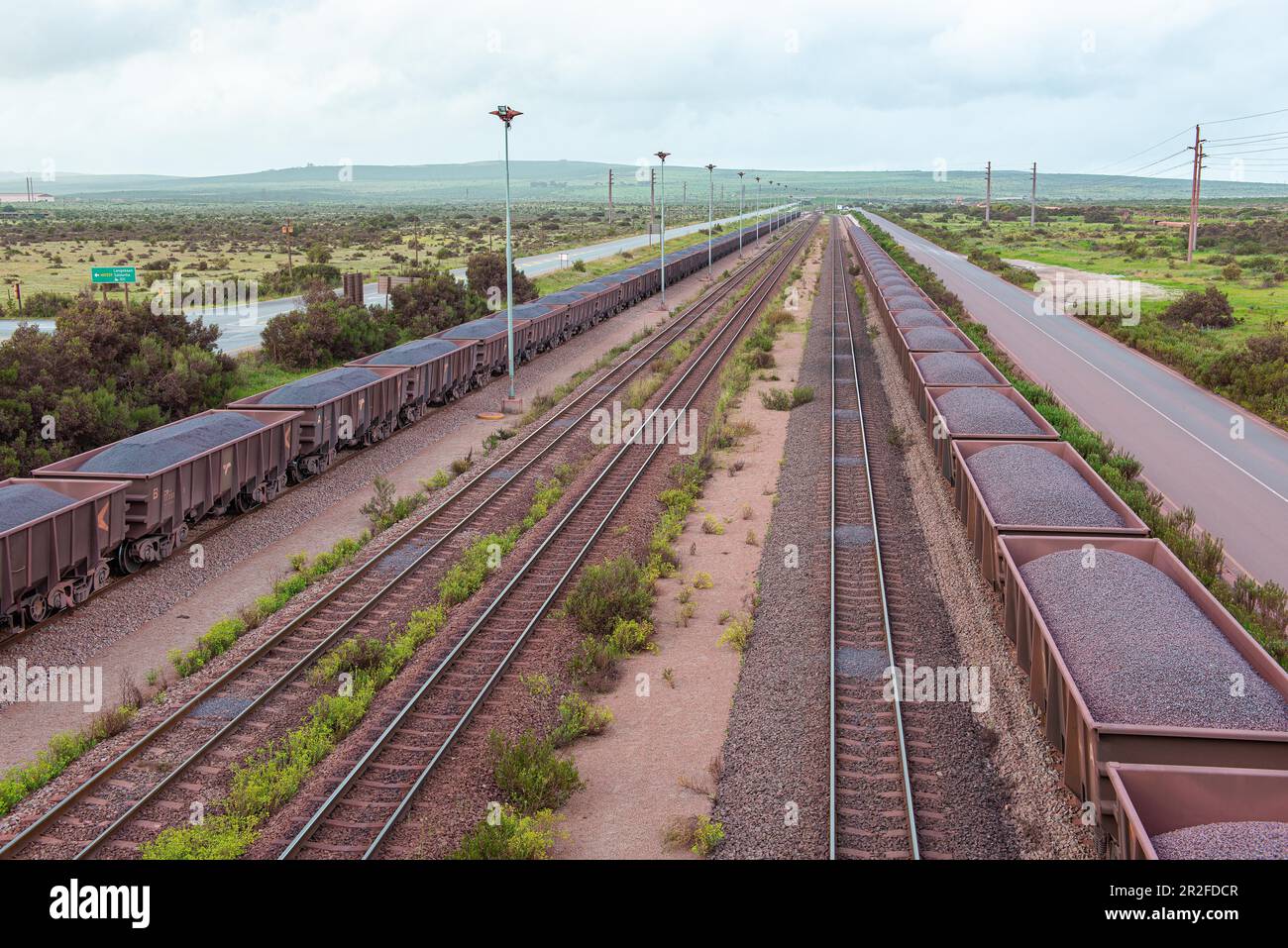 Trains de marchandises chargés de minerai de fer à l'entrée du port de chargement de minerai, Saldanha, Cap-Occidental, Afrique du Sud Banque D'Images