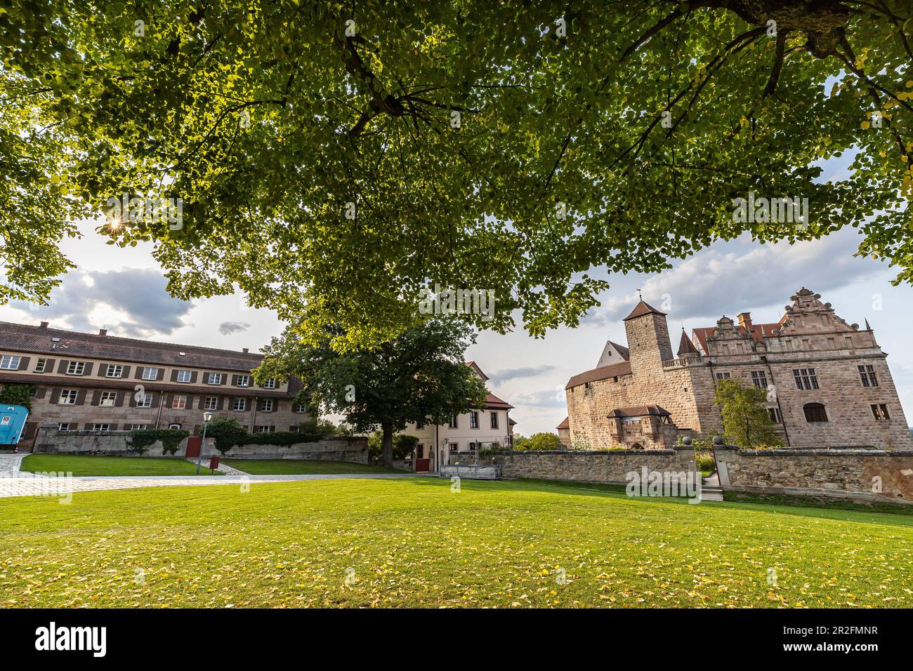 Vue sur le grand tilleul dans la cour du château de Cadolzburg en fin d'après-midi, Cadolzburg, Franconie, Bavière, Allemagne Banque D'Images