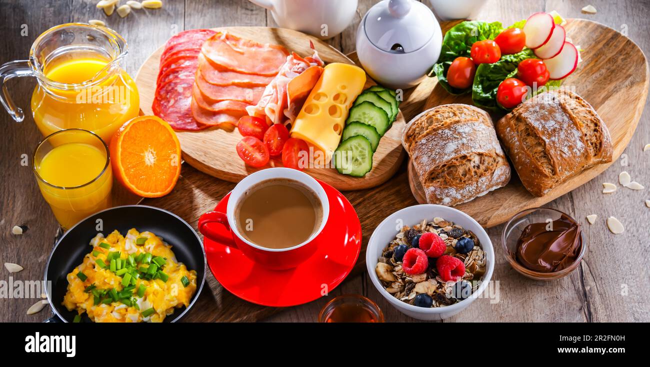 Le petit-déjeuner est servi avec du café, du jus d'orange, des œufs brouillés, des céréales, du jambon et du fromage Banque D'Images