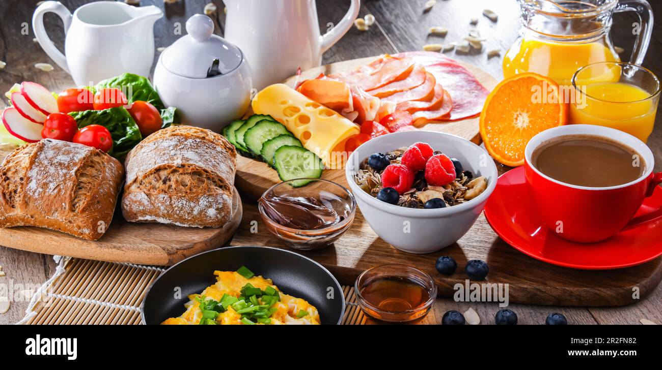 Le petit-déjeuner est servi avec du café, du jus d'orange, des œufs brouillés, des céréales, du jambon et du fromage Banque D'Images