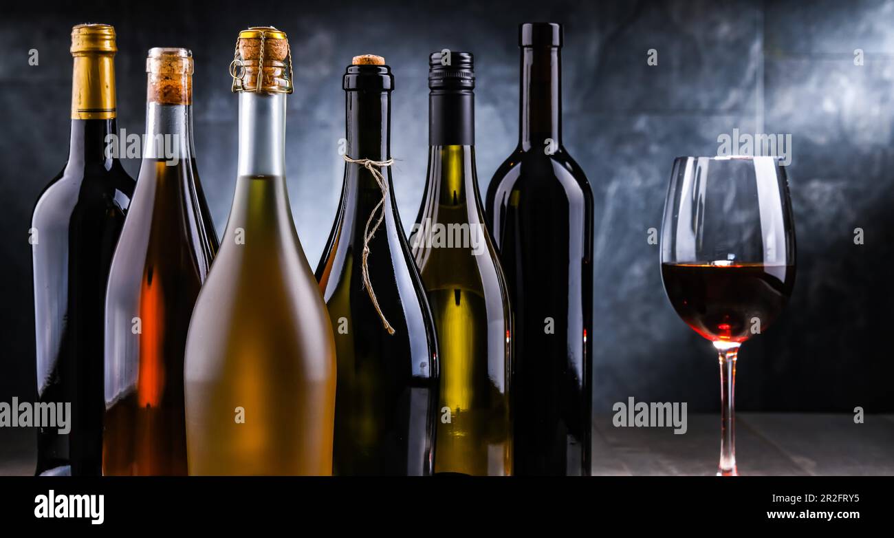 Composition avec un verre de vin et des bouteilles de différentes sortes de vin Banque D'Images