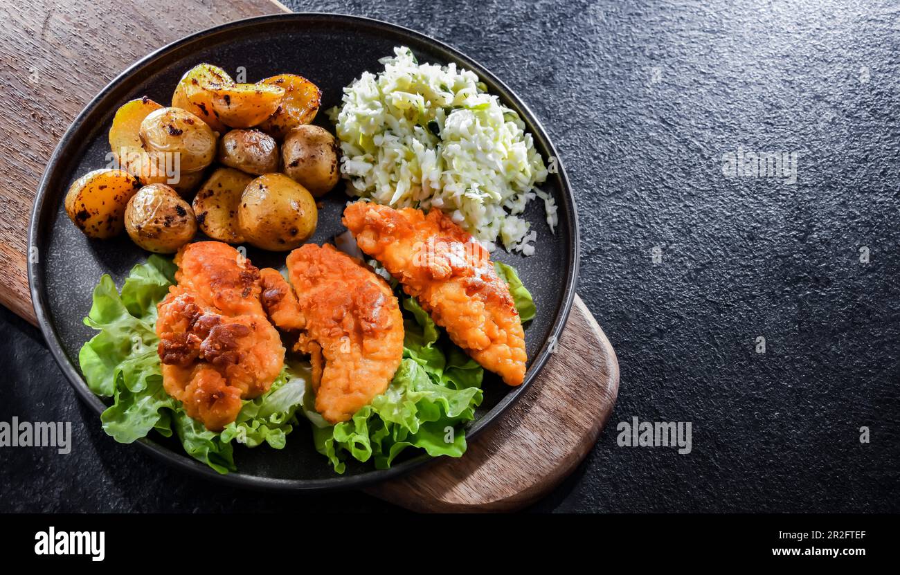 Côtelettes de poulet panées servies avec des pommes de terre et du chou Banque D'Images