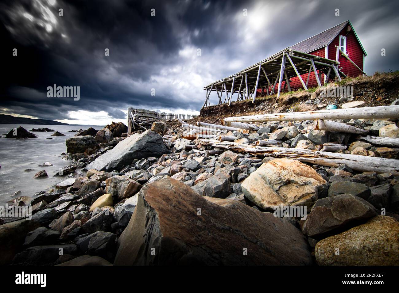 Rayonnages de séchage de morue salée en bois à exposition longue et bâtiment historique sur un rivage rocheux surplombant l'océan Atlantique à Bonavista Terre-Neuve-et-Labrador Canada. Banque D'Images