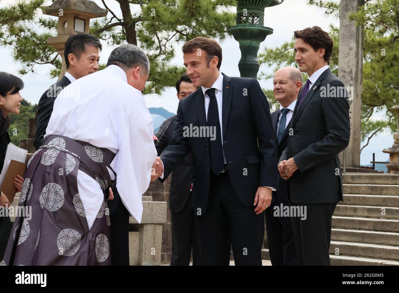 Hatsukaichi, Japon. 19th mai 2023. Le président français Emmanuel Macron, au centre, tremble la main avec le prêtre Shinto alors qu'il arrive avec le Groupe des sept dirigeants pour visiter le sanctuaire d'Itsukushima sur l'île Miyajima le premier jour du Sommet de G7, à 19 mai 2023 à Hatsukaichi, au Japon. Aux côtés de Macron, il y a le chancelier allemand OLAF Schotz et le premier ministre canadien Justin Trudeau, à droite. Crédit: Photo de piscine/G7 Hiroshima/Alamy Live News Banque D'Images