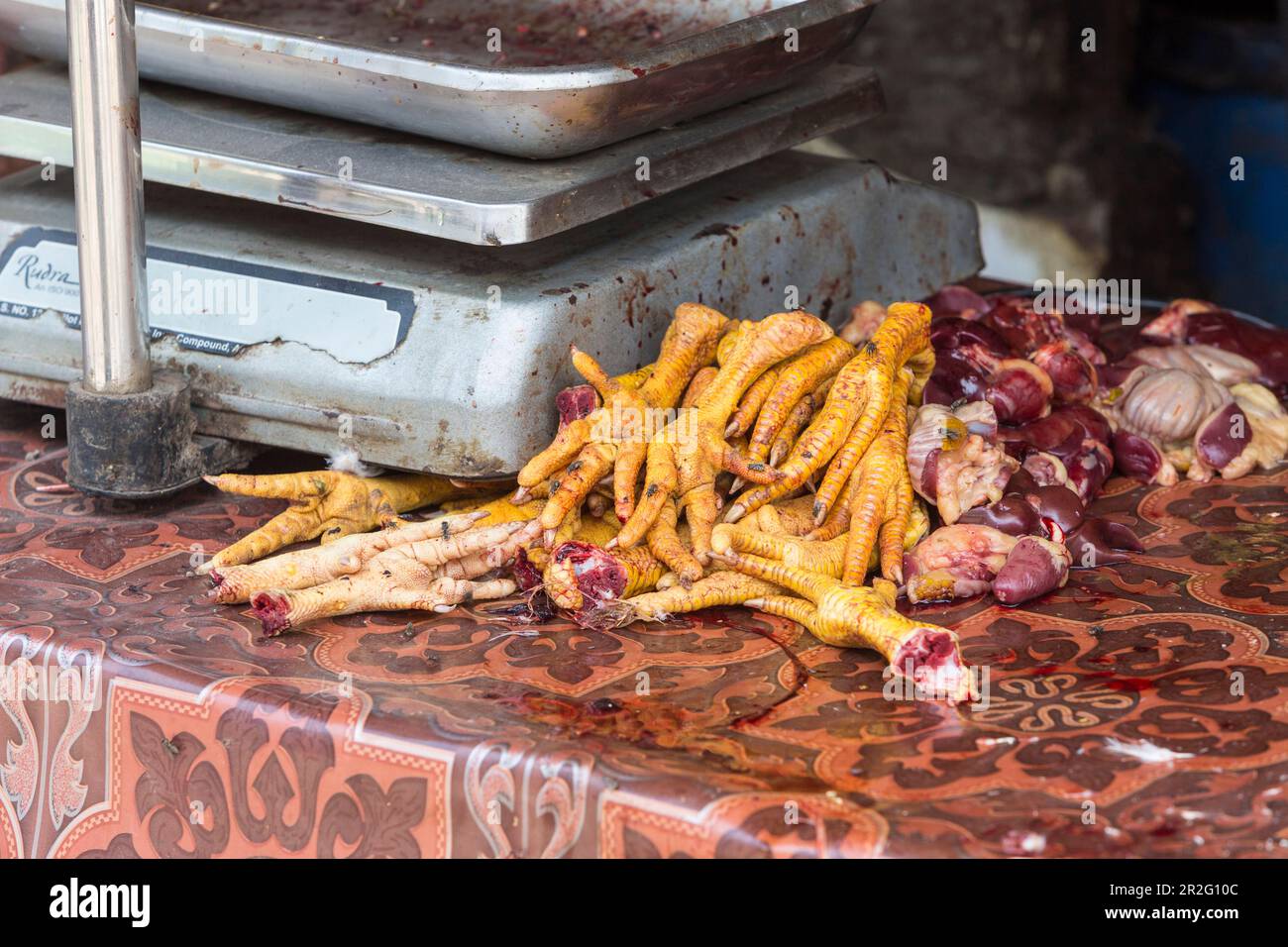 Crawford Market, aujourd'hui le nom de Mahatma Jyotiba Phule Market, marché de gros pour la viande, un homme coupe la volaille en pièces, les têtes et les pieds de poulet sont également Banque D'Images