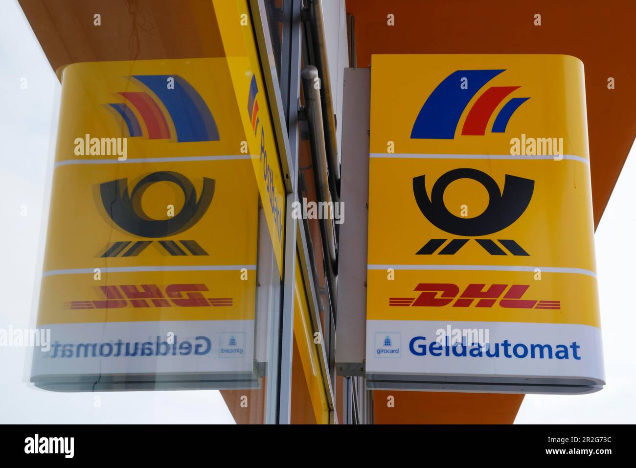 Panneau avec lettrage et logo DHL, distributeur automatique de billets, réflexion, Rhénanie-du-Nord-Westphalie, Allemagne Banque D'Images