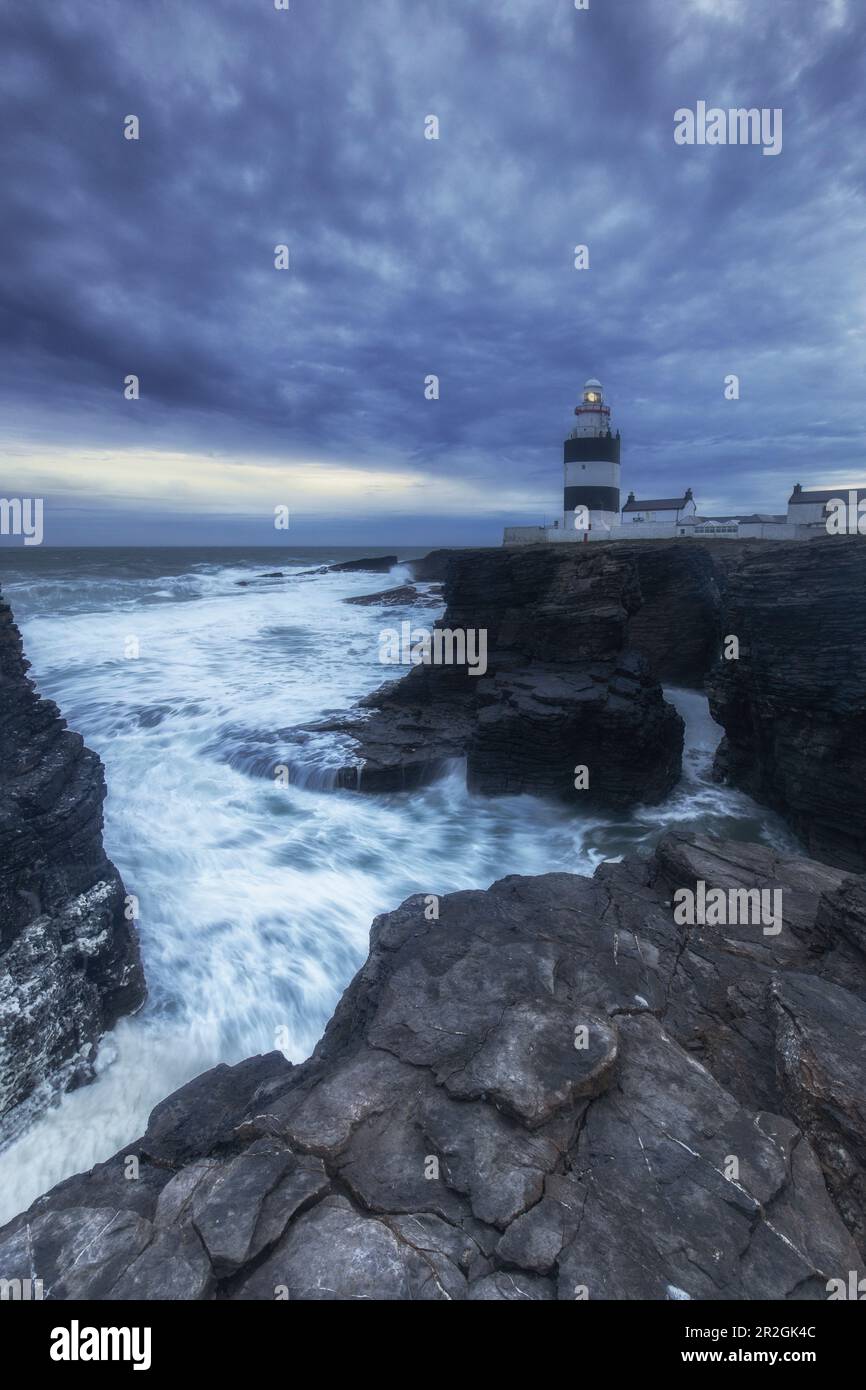 Loop Head phare sur les falaises dans les mers de tempête. Après le coucher du soleil. Churchtown, Comté de Wexford, Ireland.tif Banque D'Images