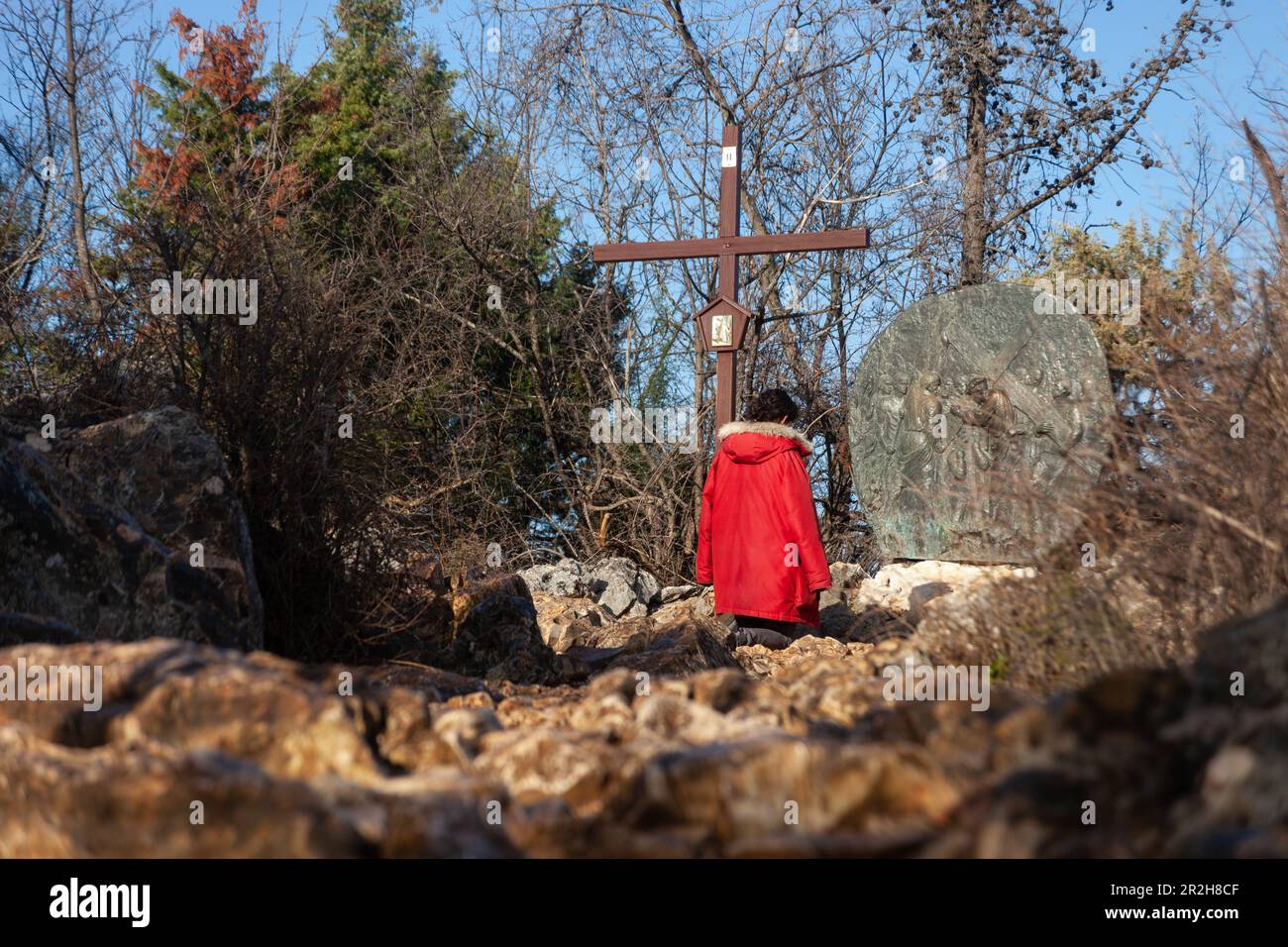 Une femme s'agenouillant dans la prière à la gare 2nd du chemin de la Croix sur le Mont Križevac à Medjugorje. Banque D'Images