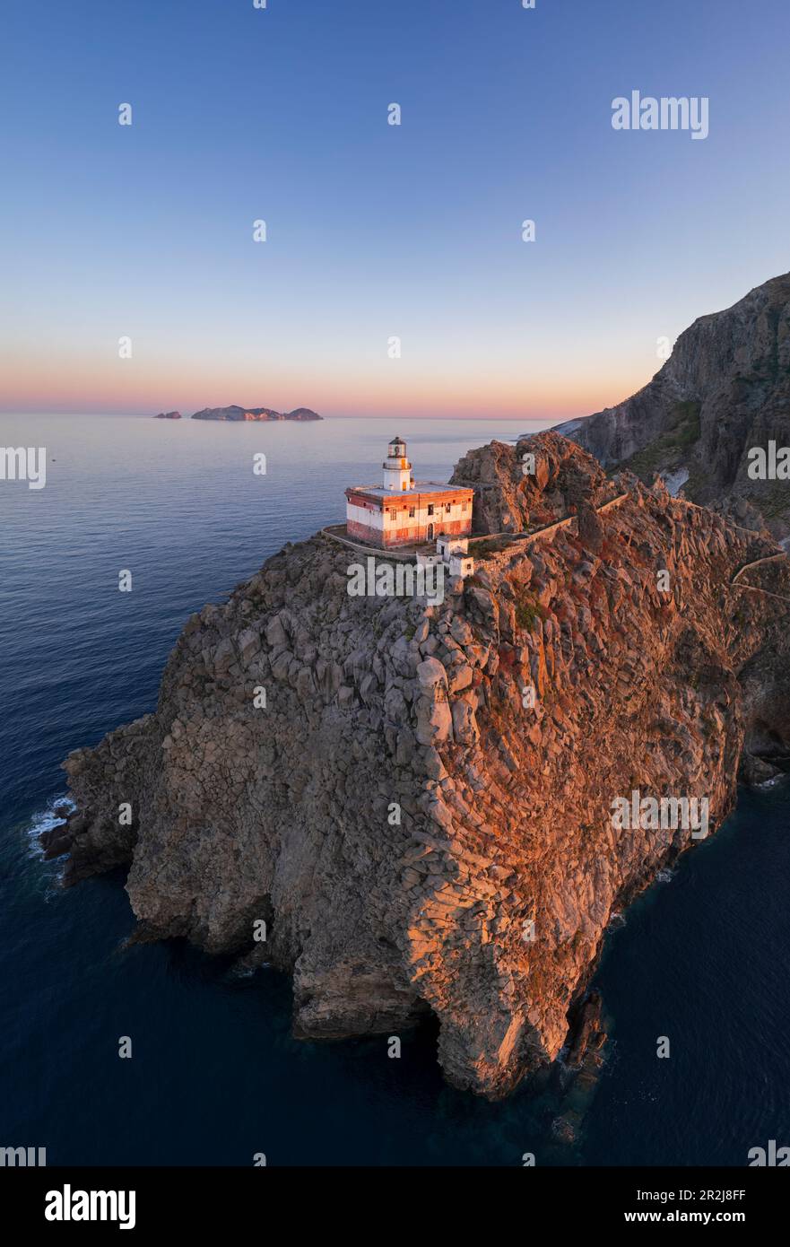 Vue panoramique aérienne du phare de l'île de Ponza, Punta della Guardia, debout au sommet d'une falaise face à la mer au crépuscule, île de Ponza Banque D'Images