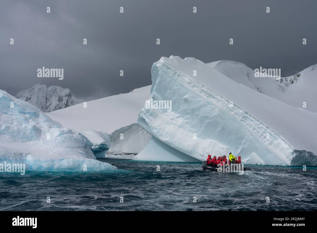 Touristes dans un bateau gonflable explorant l'île de Pleneau, l'Antarctique, les régions polaires Banque D'Images